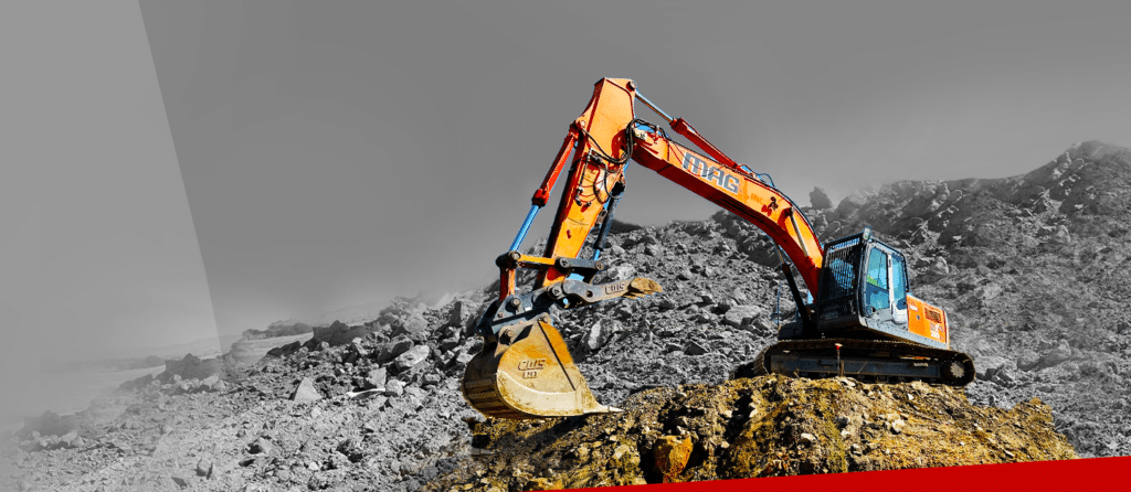 An image of an excavator on top of a rock showcasing mag engineering.