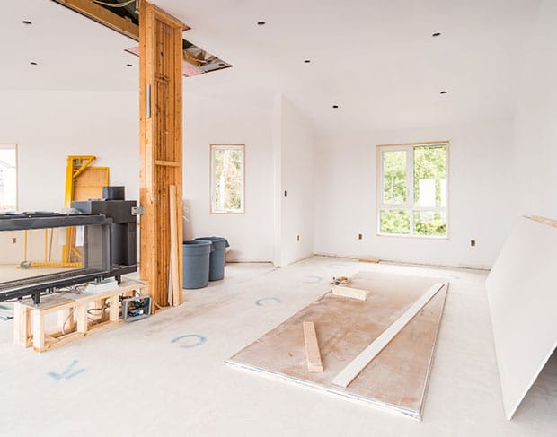 A room that is being remodeled with wood beams by demolition contractors.