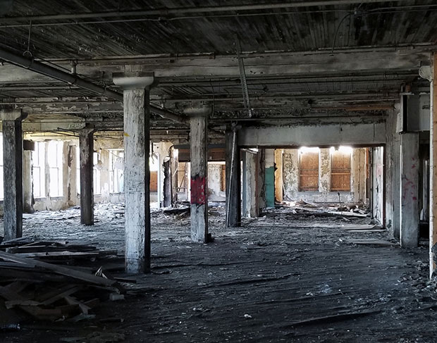 The interior of an abandoned building with a lot of rubble, where demolition contractors might be needed.