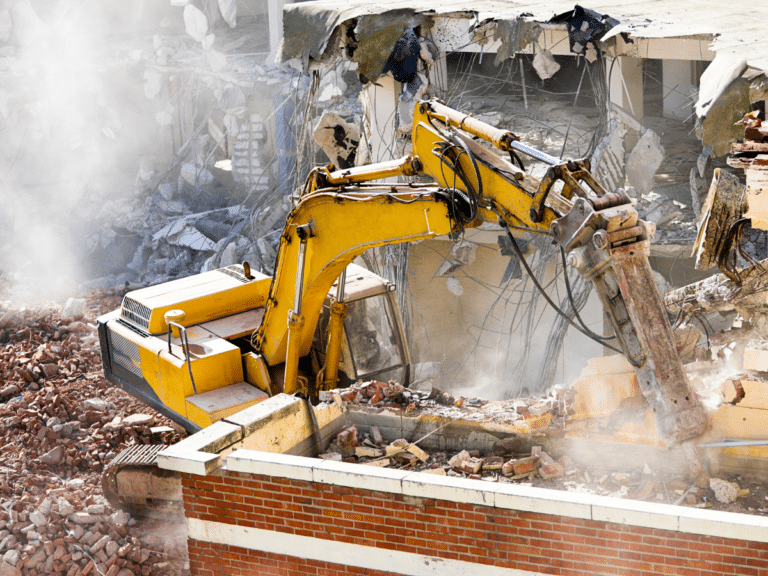 A commercial demolition excavator is digging up a building.